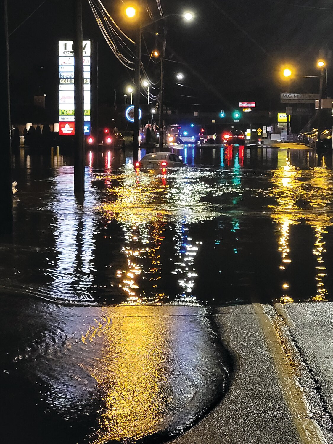LIKE A BOBBER: Later Monday night, a stranded vehicle continued to float around a flooded Atwood Avenue as the waters rose, but tow trucks were unable to reach it until the waters receded.